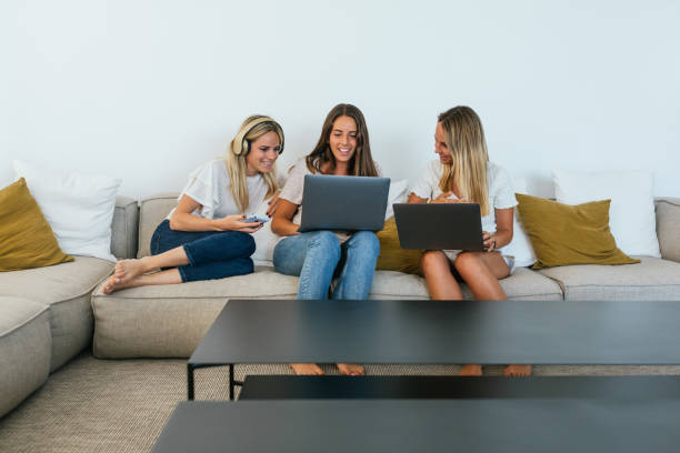 Free Stock Photo of Three People Sitting on a Couch Looking at a Laptop ...
