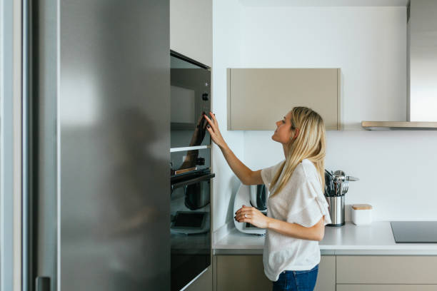 istock Woman turning on microwave oven 2159950182