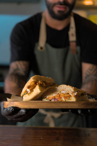 istock Chef Presenting a Delicious Sandwich on a Wooden Tray 2159951491