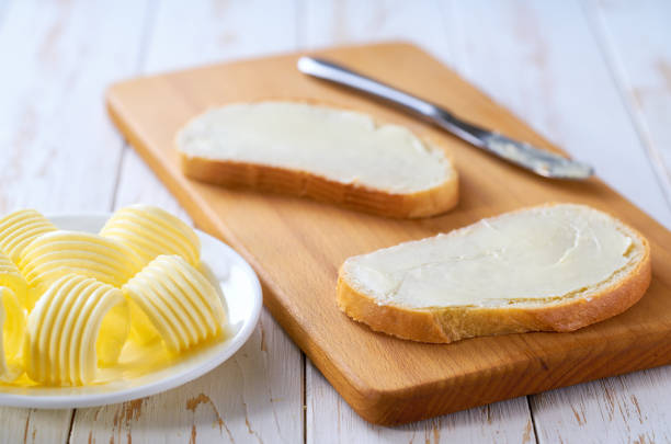 istock spread butter on a slice of wheat bread on a cutting board, selective focus. 2159951645