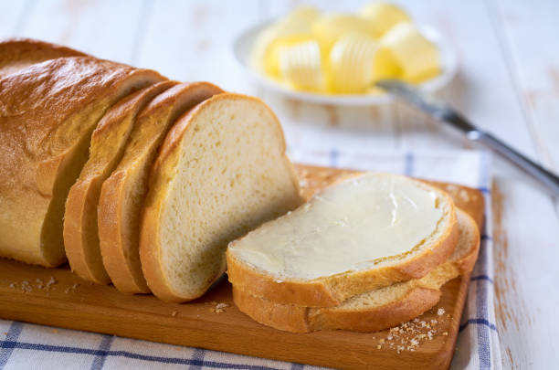 istock Delicious white wheat bread and fresh butter on a light wooden table, selective focus. 2159951652