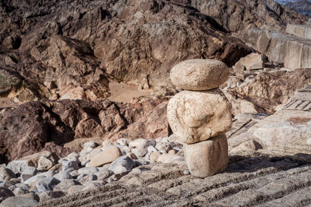 istock Stacked stones, meticulously balanced, with a rugged terrain in the background 2159953917