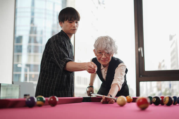 istock Senior asian woman learning and practicing billiards in a bar 2159957347