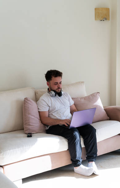istock Young man shopping online using laptop at home 2159958665