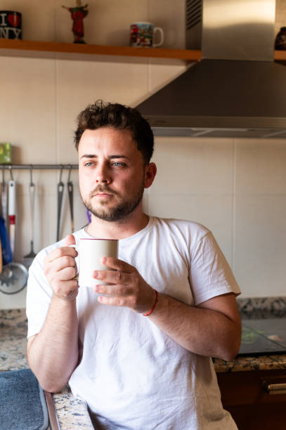 istock Thoughtful young man drinking coffee in kitchen 2159959006