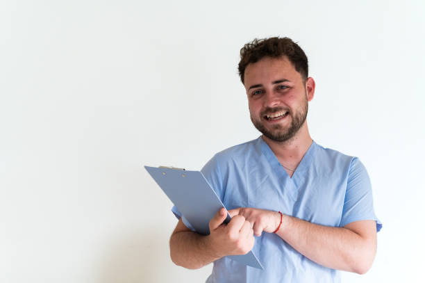 istock Young confident doctor smiling and holding a clipboard on white background 2159959558