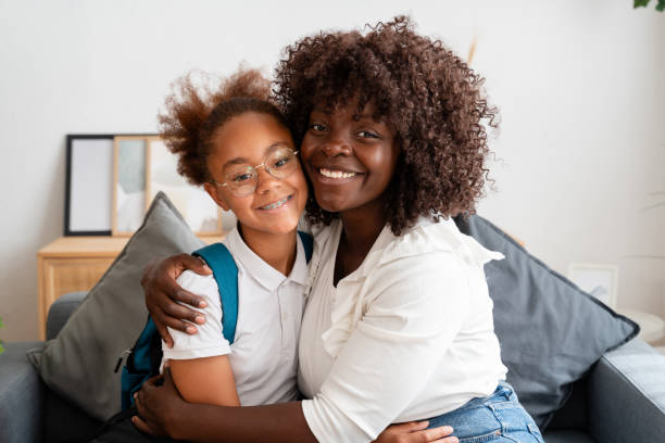 istock Mother hugging daughter wearing backpack before school 2159962980
