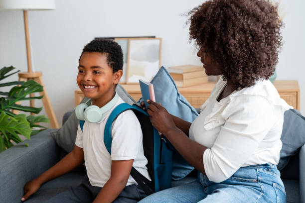 istock Mother helping son getting ready for school putting notebook in backpack 2159963121