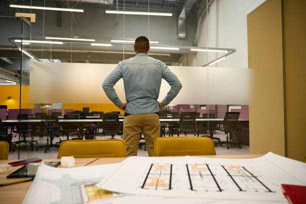 Male manager standing in office while putting hands on hips