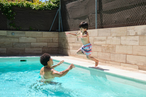 istock A boy jumping to his father into a pool 2159965386