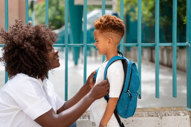 istock Caring mother adjusting backpack of son going back to school 2159966026