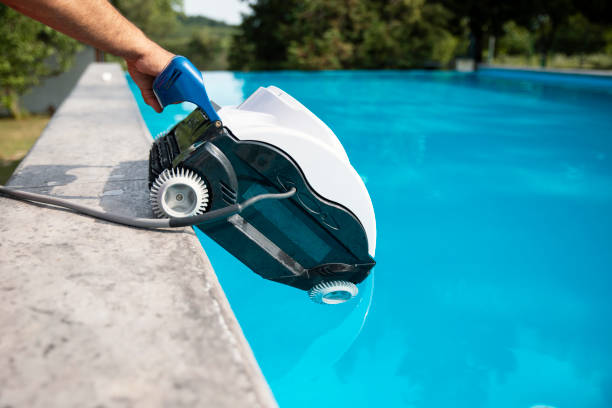 Pool cleaner automatic robot Automatic pool cleaner robot for maintenance before swimming. Submersible robot with cable for cleaning the walls and floor of the pool in Summer. Male Person putting the pool robot in the water immersed in their work stock pictures, royalty-free photos & images