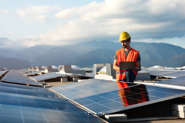 istock Technician using tablet and checking solar power plant installed on building roof 2159977730
