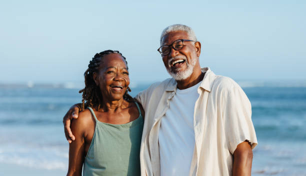 istock Joyful elderly black couple walking on a beach 2159979313