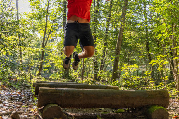 istock Man Mid-Jump Over Logs in Forest 2159982181