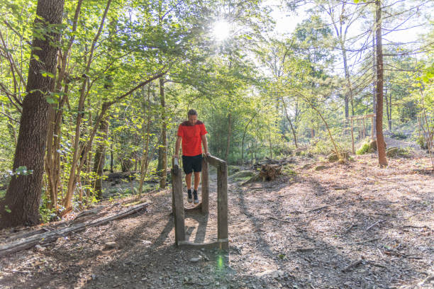 istock Man Performing Dips on Wooden Rail in Forest 2159982372