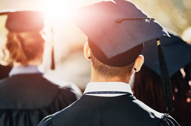 istock Graduation cap, back and students at university event on campus with education, opportunity and achievement. College, scholarship and group of people at ceremony with knowledge, learning and progress 2159982627