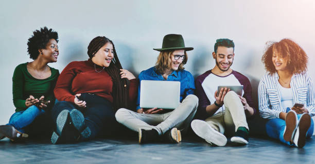 istock Group, friends and students with technology on floor for social media, learning or study. Diversity, team and happy people on tablet, phone or read knowledge on laptop for online education at college 2159983397
