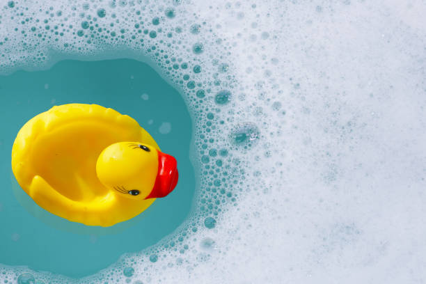 istock Yellow rubber duck in water with soap foam 2159984383