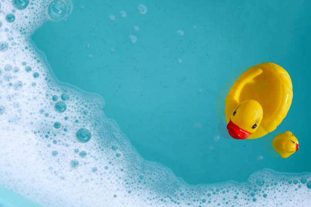 istock Yellow rubber ducks in water with soap foam 2159986275