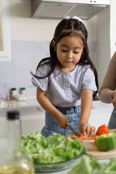 istock Latina Girl Helping in Kitchen with Fresh Vegetables 2159986799