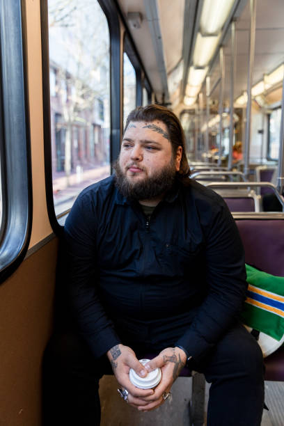 istock Urban Tattooed Man Commutes on Public Transit Train Through City 2159987051