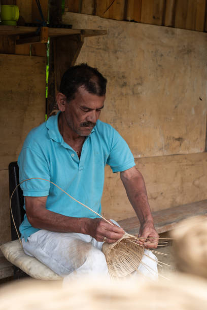istock Latin Man Weaving Basket in Rustic Workshop 2159988629