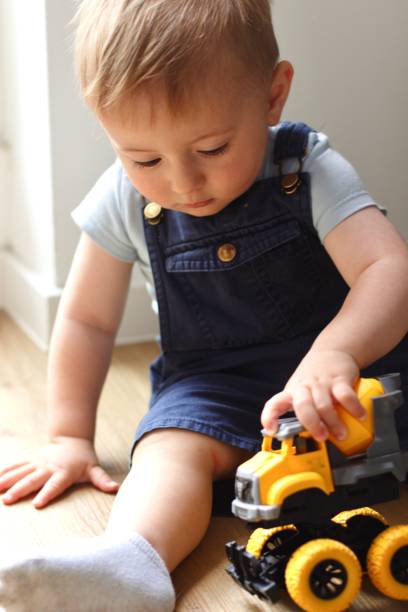 istock A small child plays with a toy car while sitting by the window 2159991210