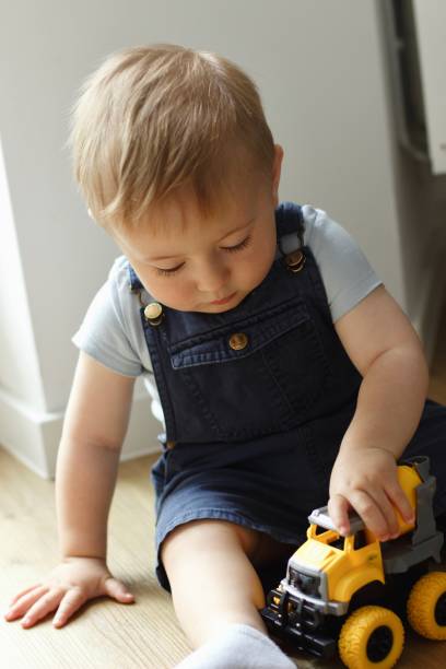 istock A small child plays with a toy car while sitting by the window 2159991225