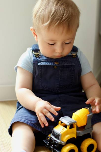 istock A small child plays with a toy car while sitting by the window 2159991254