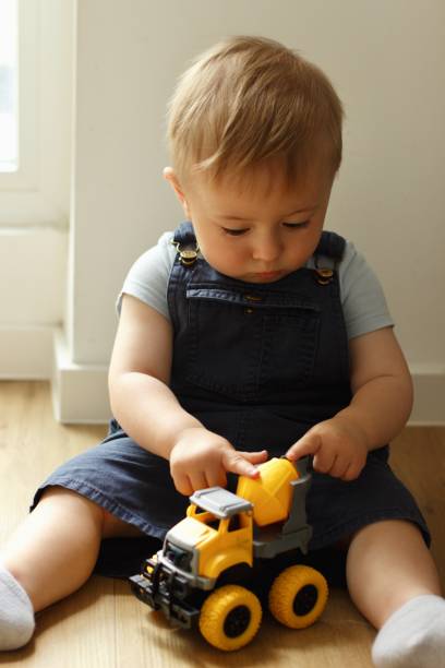 istock A small child plays with a toy car while sitting by the window 2159991259