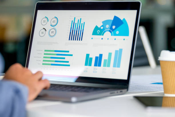 istock Close up of businessman using a laptop with graphs and charts on a laptop computer. 2159991609