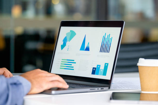 istock Close up of businessman using a laptop with graphs and charts on a laptop computer 2159991665