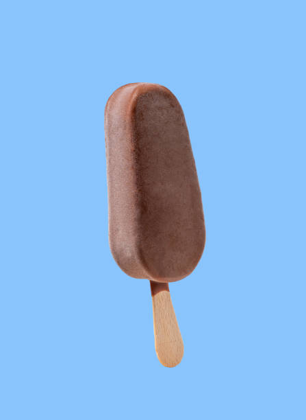 istock Chocolate popsicle ice cream on a stick, isolated on a blue background. 2159992259