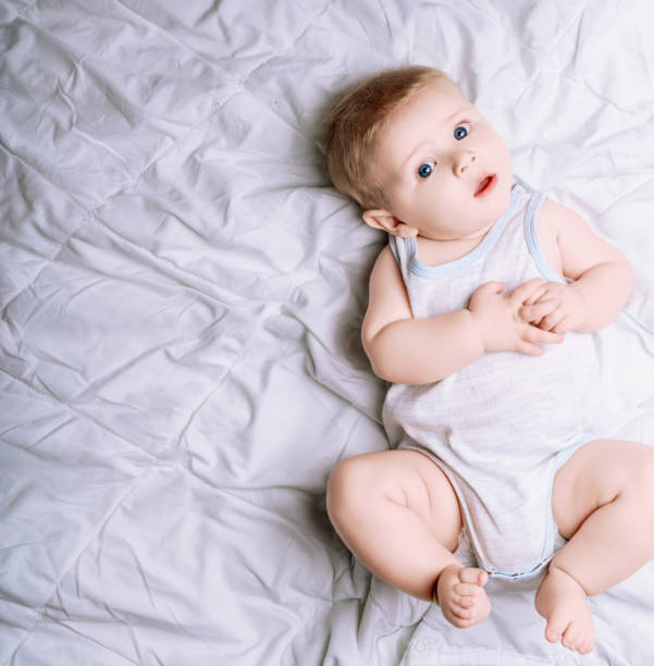 istock Baby boy relaxing on a white blanket looking up 2159995400