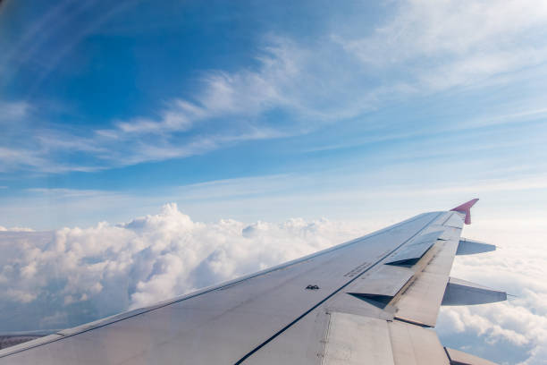 istock View from the airplane window at a beautiful cloudy sky and the airplane wing 2159996049