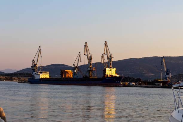 Loading onto bulk carrier ship at commercial port on a sunny day
