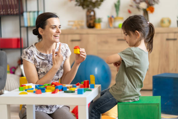 istock Educator and girl engaging with colored blocks 2160002761