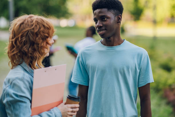 istock Close up of diverse student talking with classmate at campus on a break 2160002883
