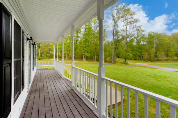 istock White Covered Porch With Railing Overlooking Greenery And Blue Sky 2160007751