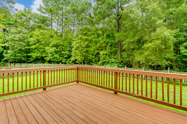 istock Sunny Wooden Deck With Railing Overlooking Lush Green Backyard in Summer 2160008019