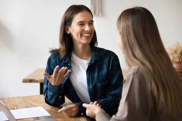 istock Cheerful young female managers talking at office workplace table 2160010994