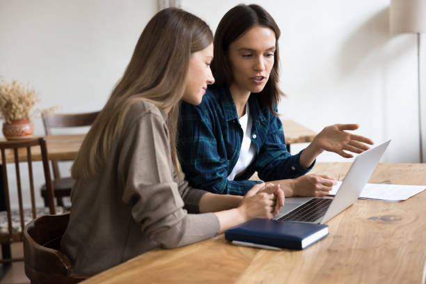 istock Serious manager presenting online project to colleague, showing online content 2160011056