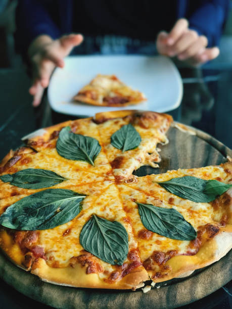 Pizza with mozzarella cheese, tomato sauce and basil leafs.