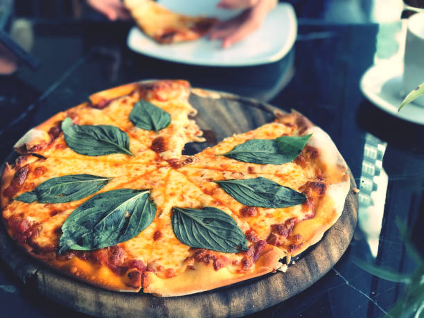 Pizza with mozzarella cheese, tomatoes and basil leaves.