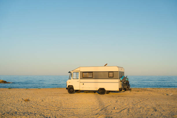 Camper van parked by the sea at sunset  at Mediterranean coast