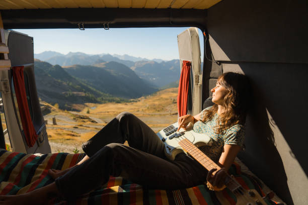 istock Woman with guitar in camper van in mountains 2160018505