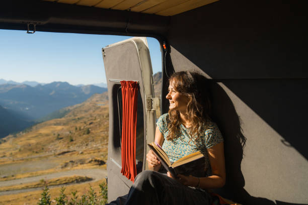 istock Woman reading book in camper van in mountains 2160018523