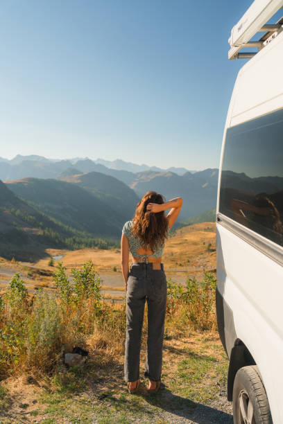 istock Woman looking at mountain pass standing near camper van 2160018532