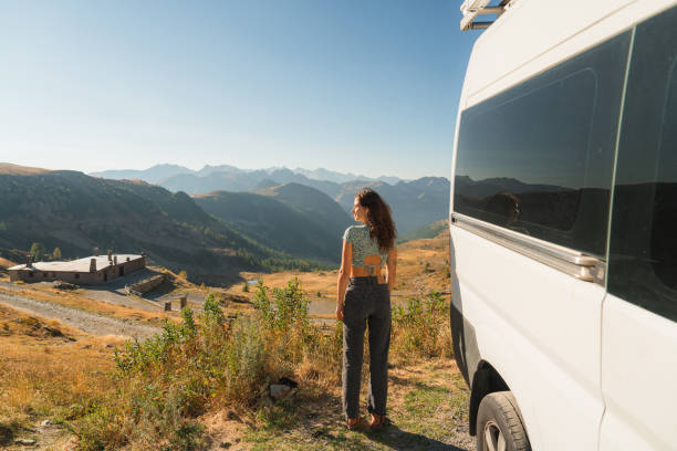 istock Woman looking at mountain pass standing near camper van 2160018543